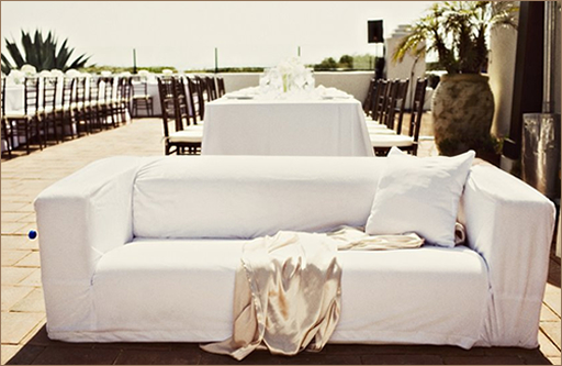 Rooftop event setup with white sofa and dining tables