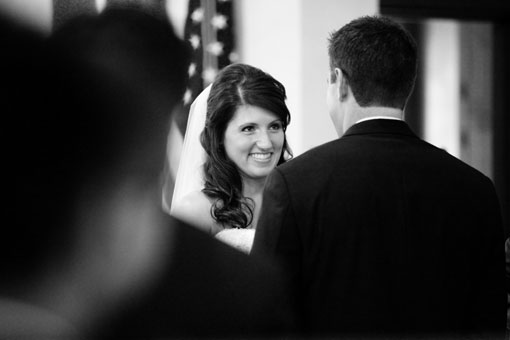 Smiling bride gazes at groom during her wedding ceremony