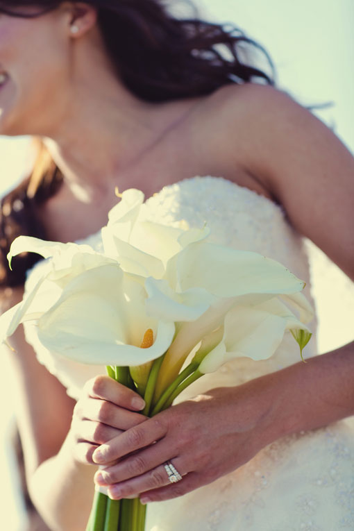 Bride in white dress holding calla lily bouquet