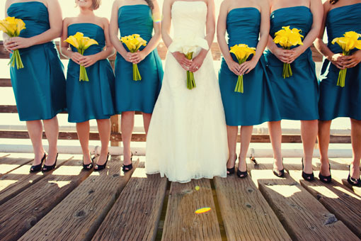 Bride and bridesmaids in teal dresses with yellow flowers