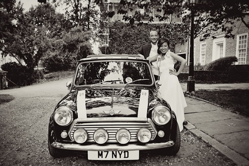 Black and white photo of newlyweds and a classic Mini