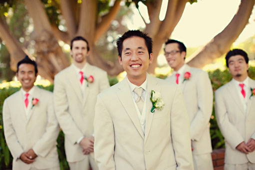 Smiling groom and groomsmen in tan suits at wedding