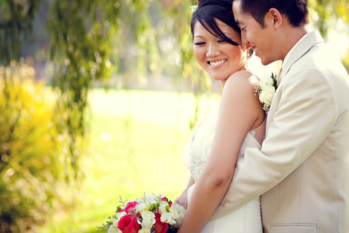 Happy Asian couple embracing at their wedding outdoor