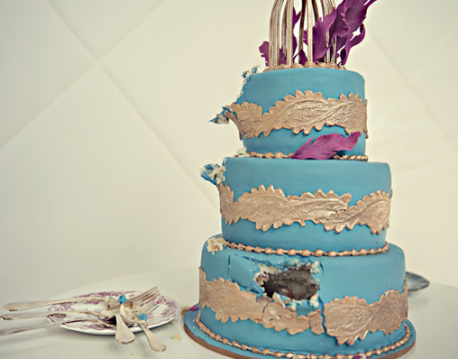 Three tier blue and gold wedding cake with birdcage