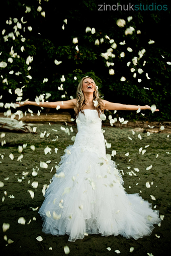 Bride joyfully showered with petals on her wedding day