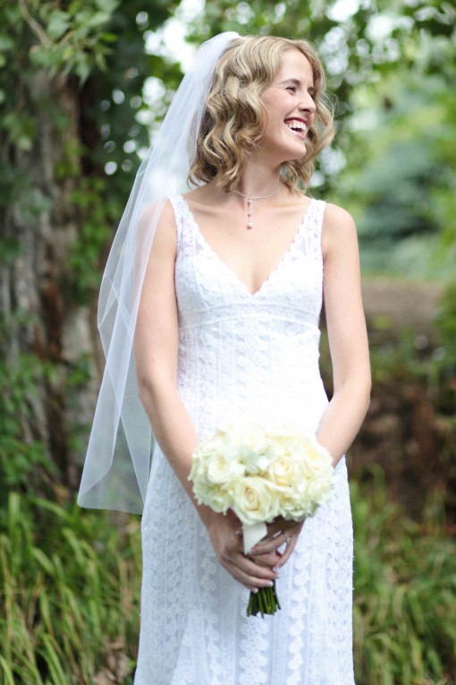 Smiling bride holding flowers on her wedding day with veil