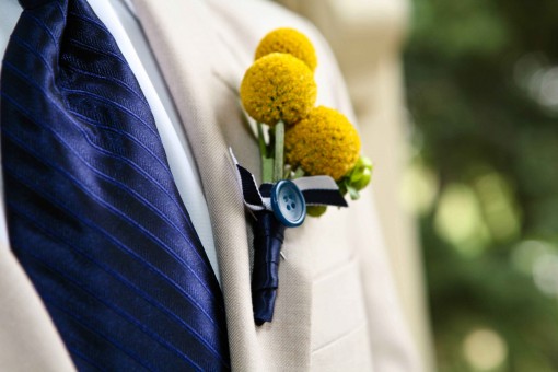 Elegant wedding attire with boutonniere and blue tie detail