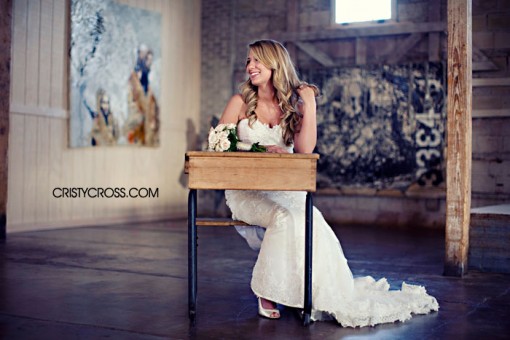 Beautiful bride in a white wedding dress smiling near old desk