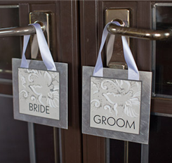 Bride and groom door signs hanging on a wooden door handles