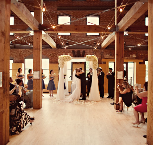 Wedding ceremony in a rustic venue with couple's embrace