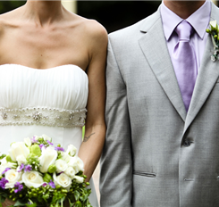 Bride and groom on their wedding day in white dress and grey suit