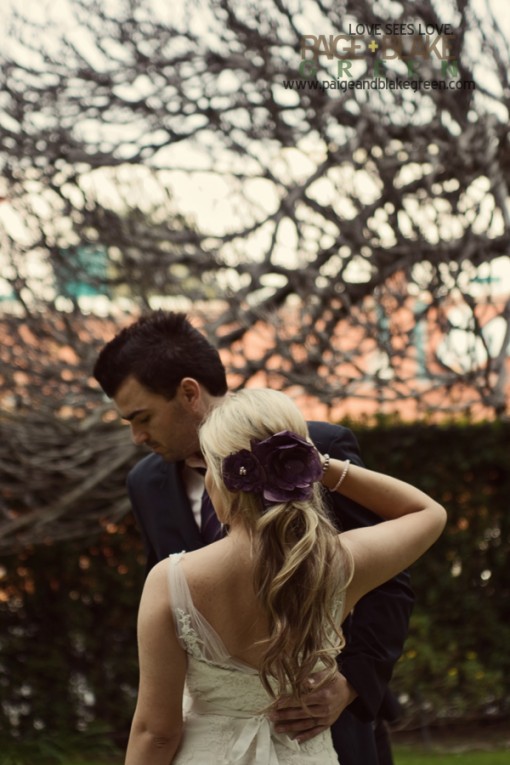 Bride and groom embracing on wedding day with flower hair piece