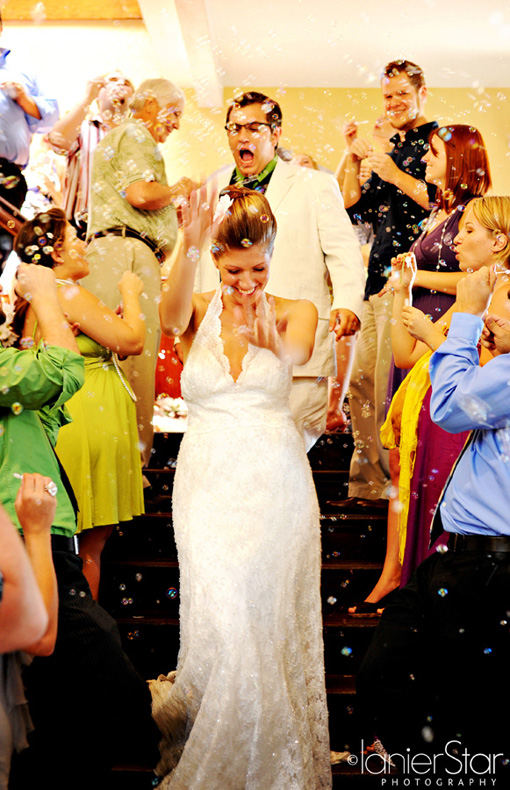 Bride and groom celebrate wedding day with bubbles and friends
