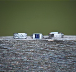 Three beautiful rings on a rough wooden surface