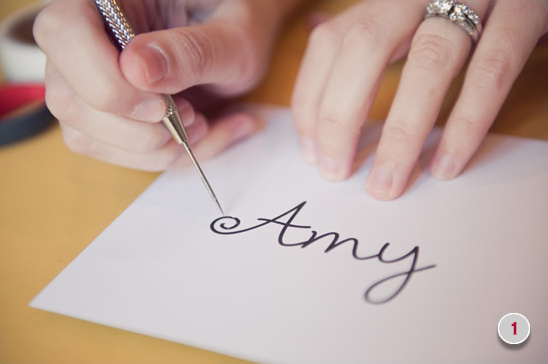 Hand lettering the name Amy onto paper using a stylus