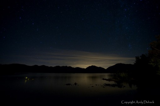Night sky over lake water reflecting starry vista