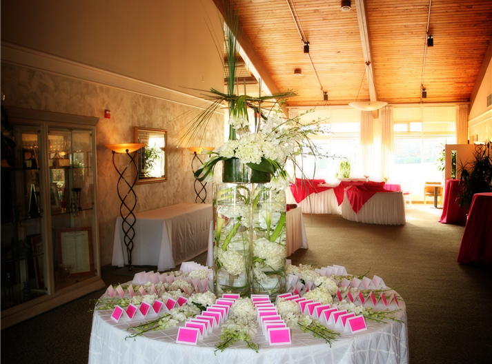 Elegant reception venue with a floral centerpiece and pink accents