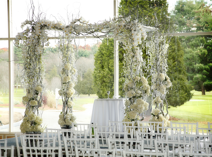 Elegant winter wedding ceremony setup with white flowers and branches