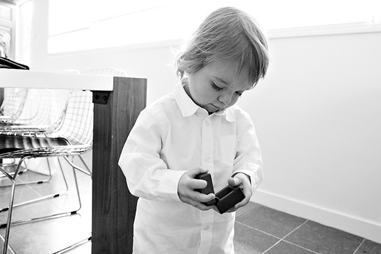 Black and white photo of boy curiously looking at box