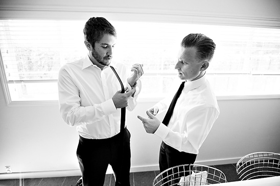Two groomsmen getting ready in black and white photograph