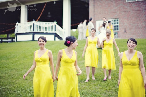 Bridesmaids in bright yellow dresses at an outdoor wedding
