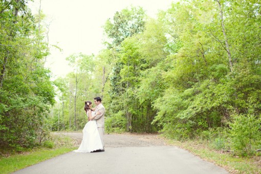 Couple embraces on forest road wedding day portrait