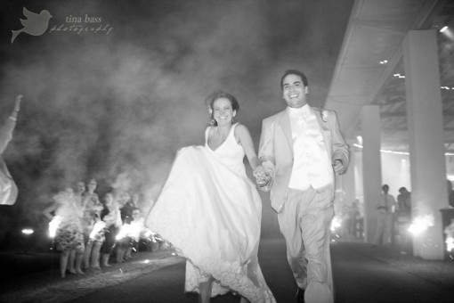 Bride and groom run through sparklers at wedding reception