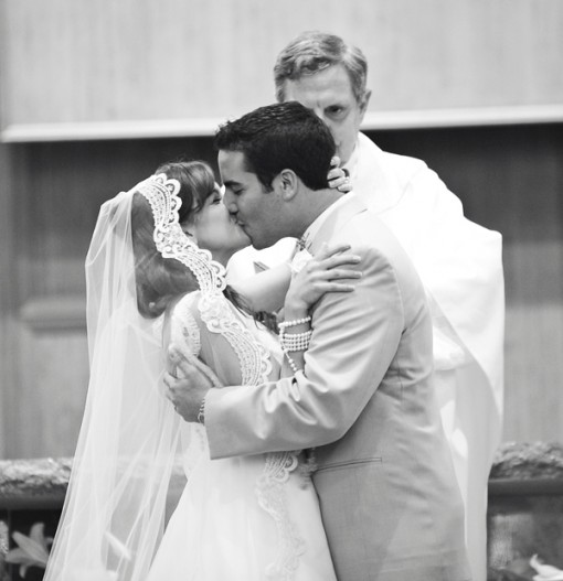 Bride and groom share a kiss at their wedding ceremony