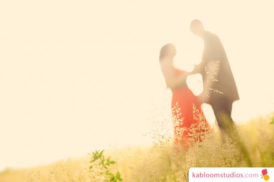 Couple dancing in a field during sunset, romantic moment captured