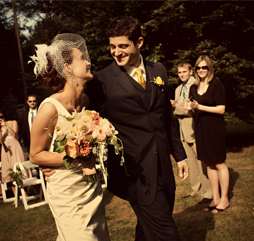 Happy couple walking after wedding ceremony with guests