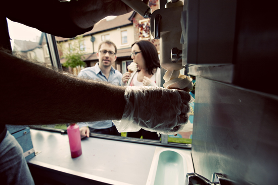 Ice cream being served from a truck with a couple in the background