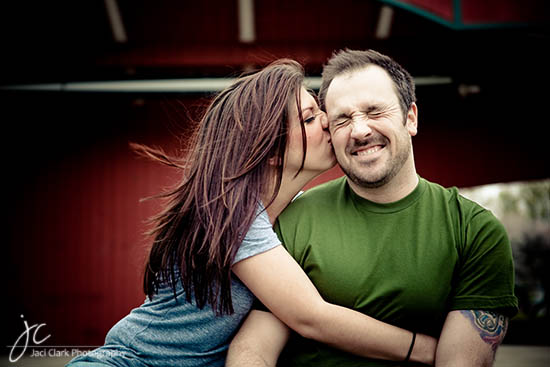Woman giving her boyfriend a kiss on the cheek with happiness
