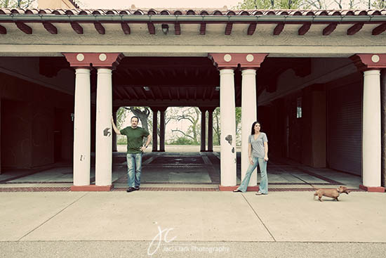 Couple with a dog posing under an arched colonnade structure