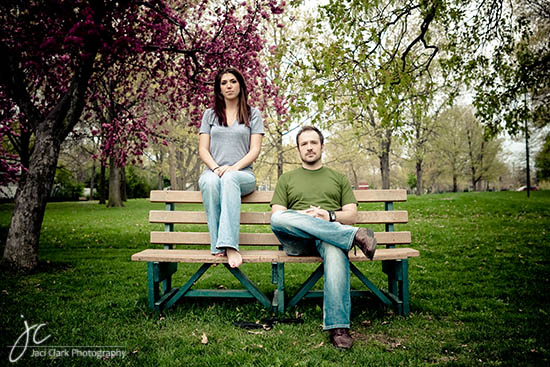 Couple sitting on a bench in a park under blossoming trees