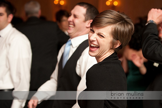 Woman winking and laughing at a lively wedding reception party