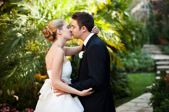 Newlyweds share a romantic kiss outdoors after the wedding