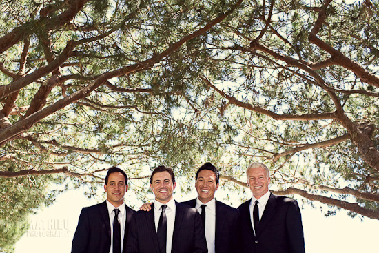 Men in suits under tree, smiling and posing for the photo