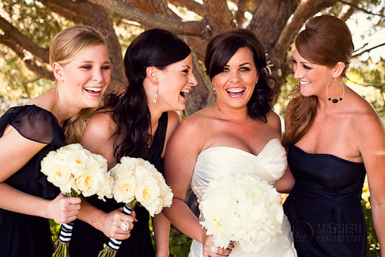 Bridesmaids laughing together on a bright sunny wedding day with bouquets