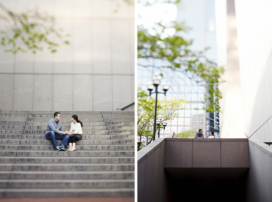 Couple holding hands on steps in a city setting with trees