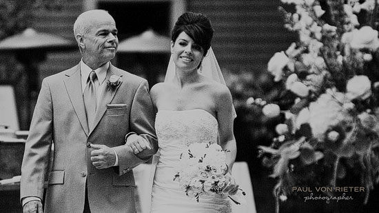 Father walking daughter down the aisle at wedding, black and white photo