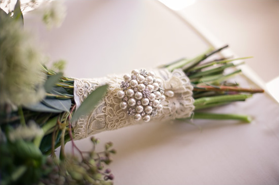 Elegant wedding bouquet with pearl brooch and lace ribbon