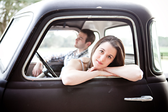 Couple in vintage black truck looking out the window
