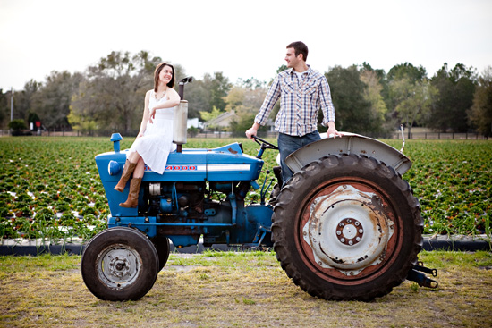 Couple on a vintage blue tractor in a field smiling