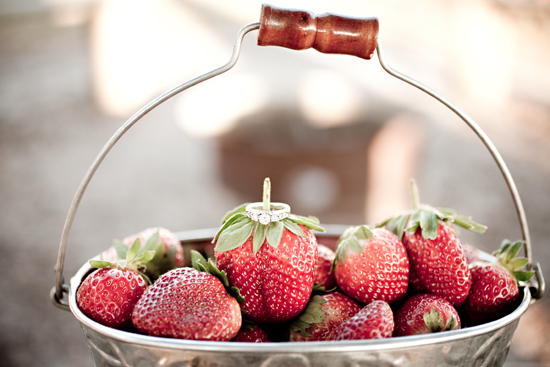 Engagement ring on a strawberry in a bucket for a wedding proposal