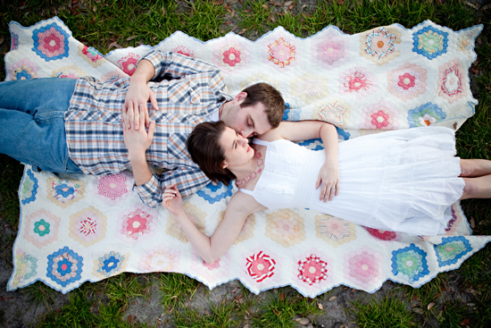 Couple embracing on a picnic blanket, intimate moment on grass