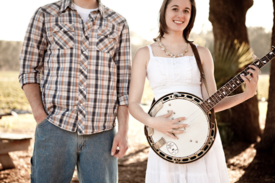 Couple with banjo outdoors country western style smiling