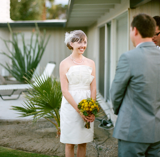 Smiling bride in a white dress with bouquet, awaiting her groom at altar
