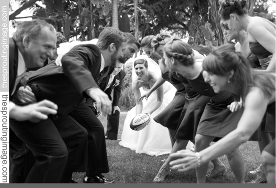 Wedding party playing rugby in the grass, a fun group activity
