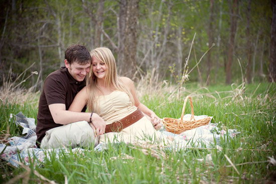 Young couple enjoys a romantic picnic in a grassy field with smiles