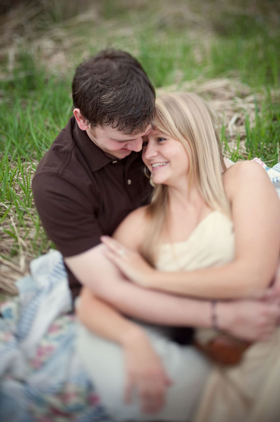 Couple embracing and smiling in a meadow, engagement photo